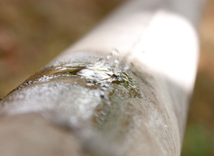 Leak of water from a crack in an old rusty pipe