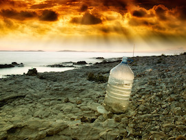 Last bottle of collected fresh water on the coast near the sea.